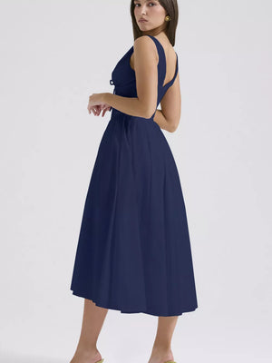 Navy V-neck midi dress with a-line skirt and tie detail at bust.