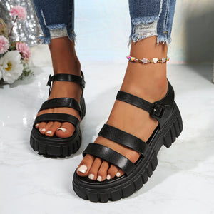 Black open-toe platform sandals with three straps and buckle closure.
