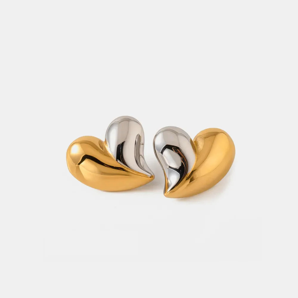 Two-tone heart sculptural stud earrings in gold and silver.