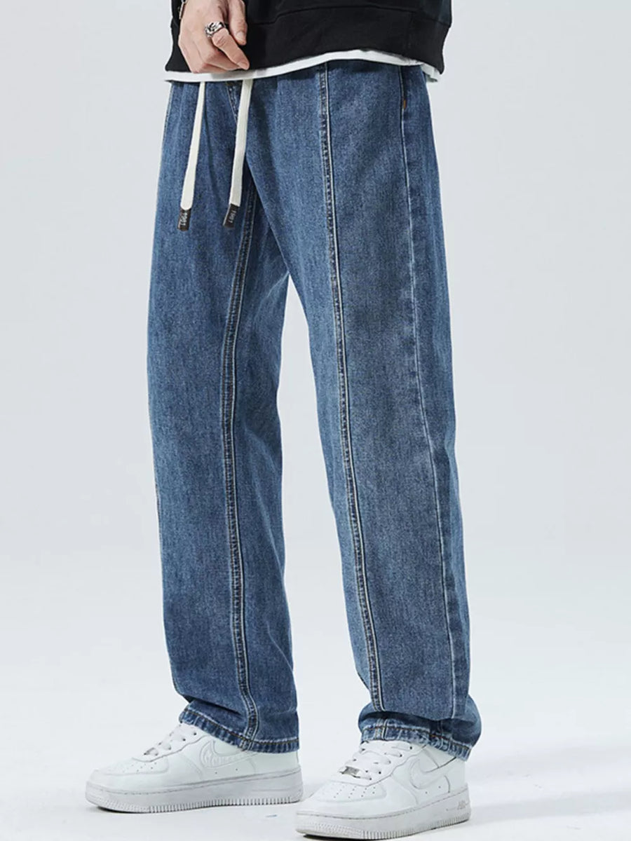 Men's light blue 100% cotton loose-fit jeans with drawstring waist and front seam detail.