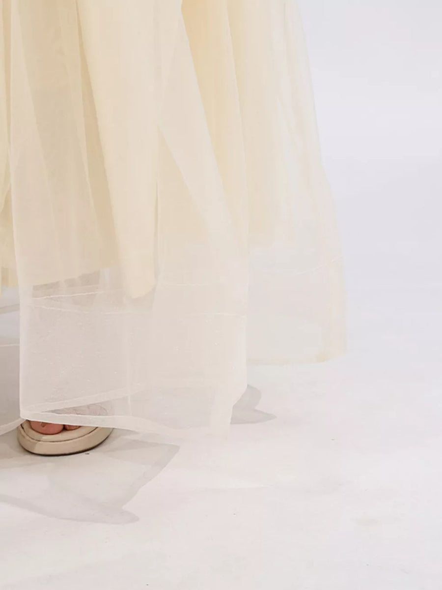 Cream tulle maxi skirt with subtle sparkle detail and a sheer hem.