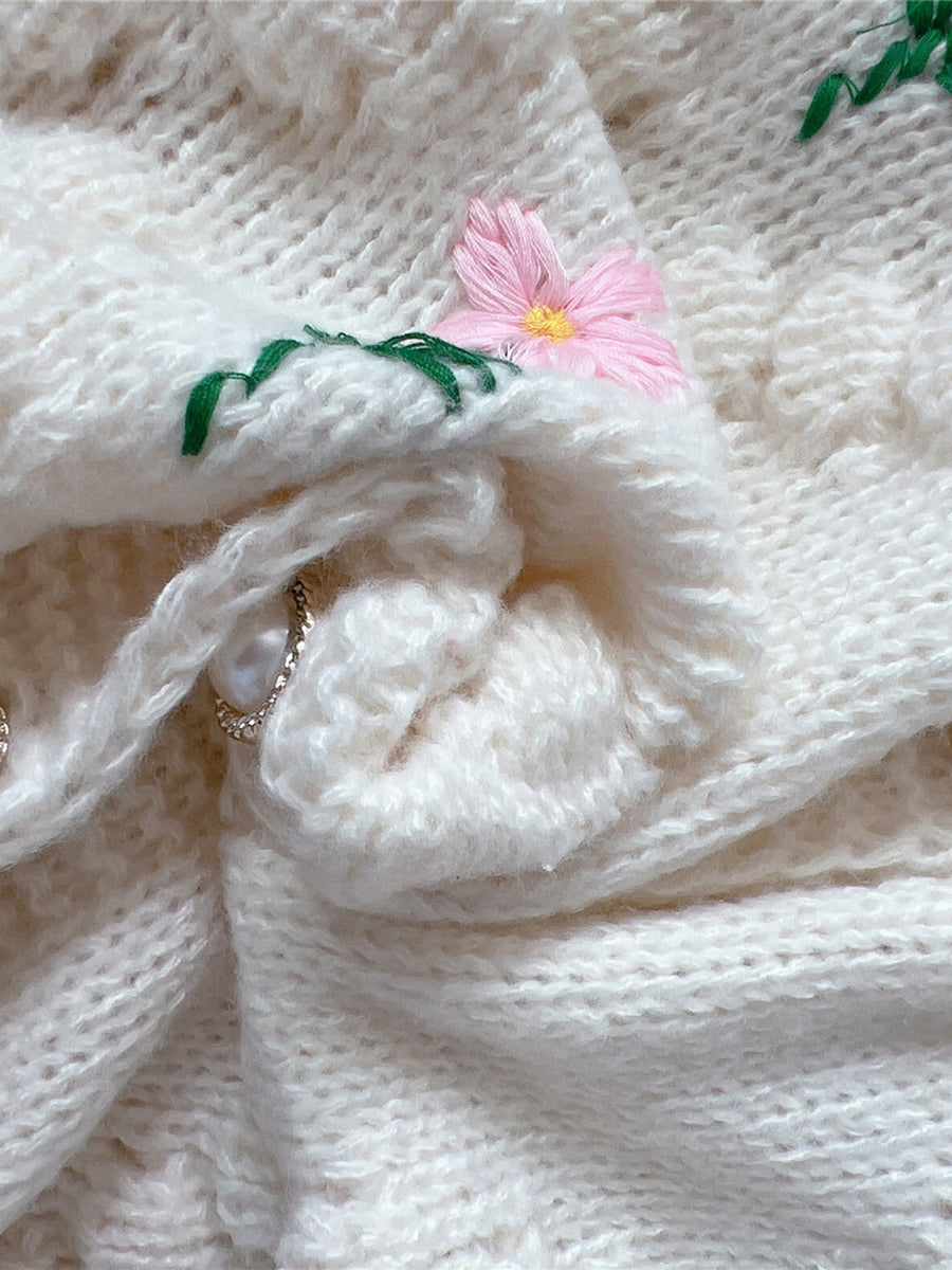 Cream bobble stitch cardigan with pink floral embroidery and pearl button detail.