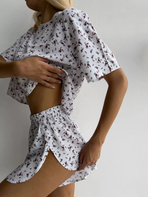 White floral print lounge set with relaxed fit top and split hem shorts.