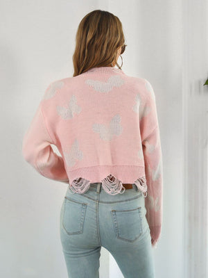 Blush pink distressed knit cropped sweater with white butterfly print and frayed hem.