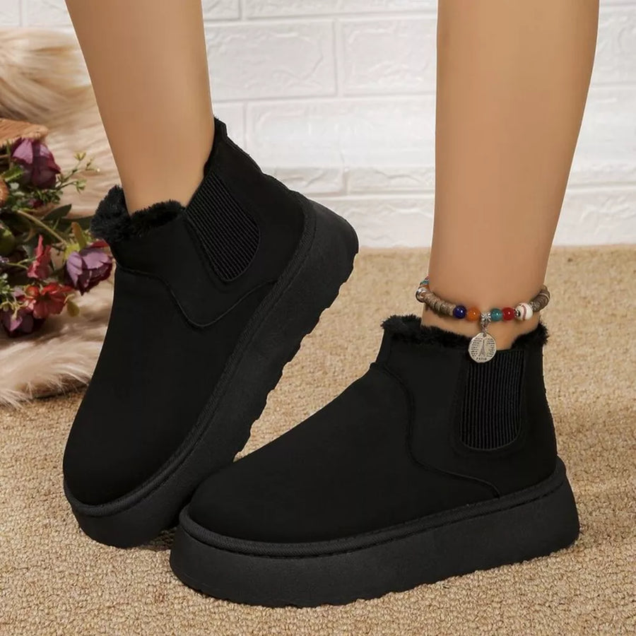 Black suede round toe platform ankle boots with faux fur trim and elastic side panels.