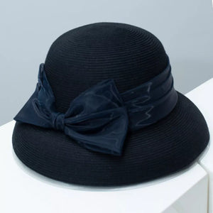 Black straw sun hat with a large satin bow detail.