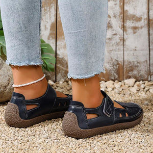 Blue leather cutout flat shoes with white stitching and a textured sole.