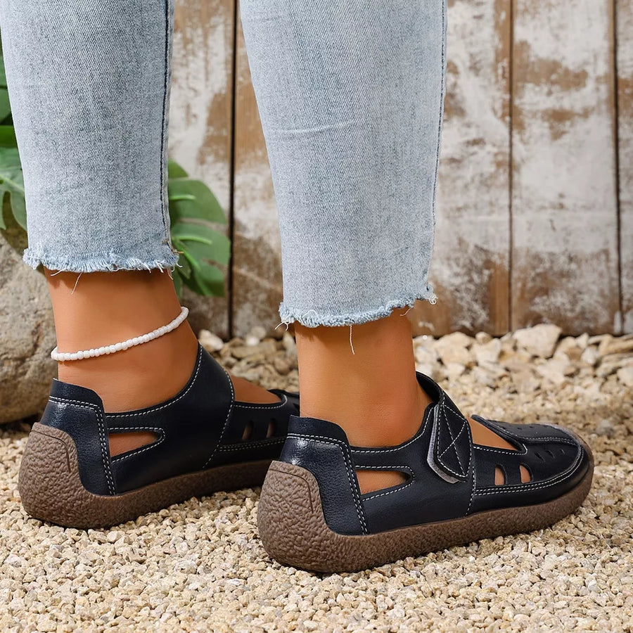 Blue leather cutout flat shoes with white stitching and a textured sole.