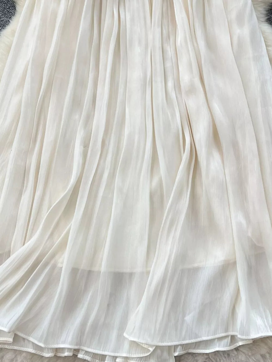 Cream pleated maxi skirt with flowing fabric and delicate pleats.