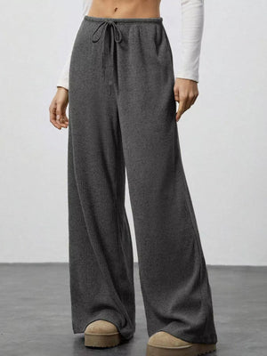 Dark gray ribbed wide-leg pants with drawstring waist and a relaxed fit.