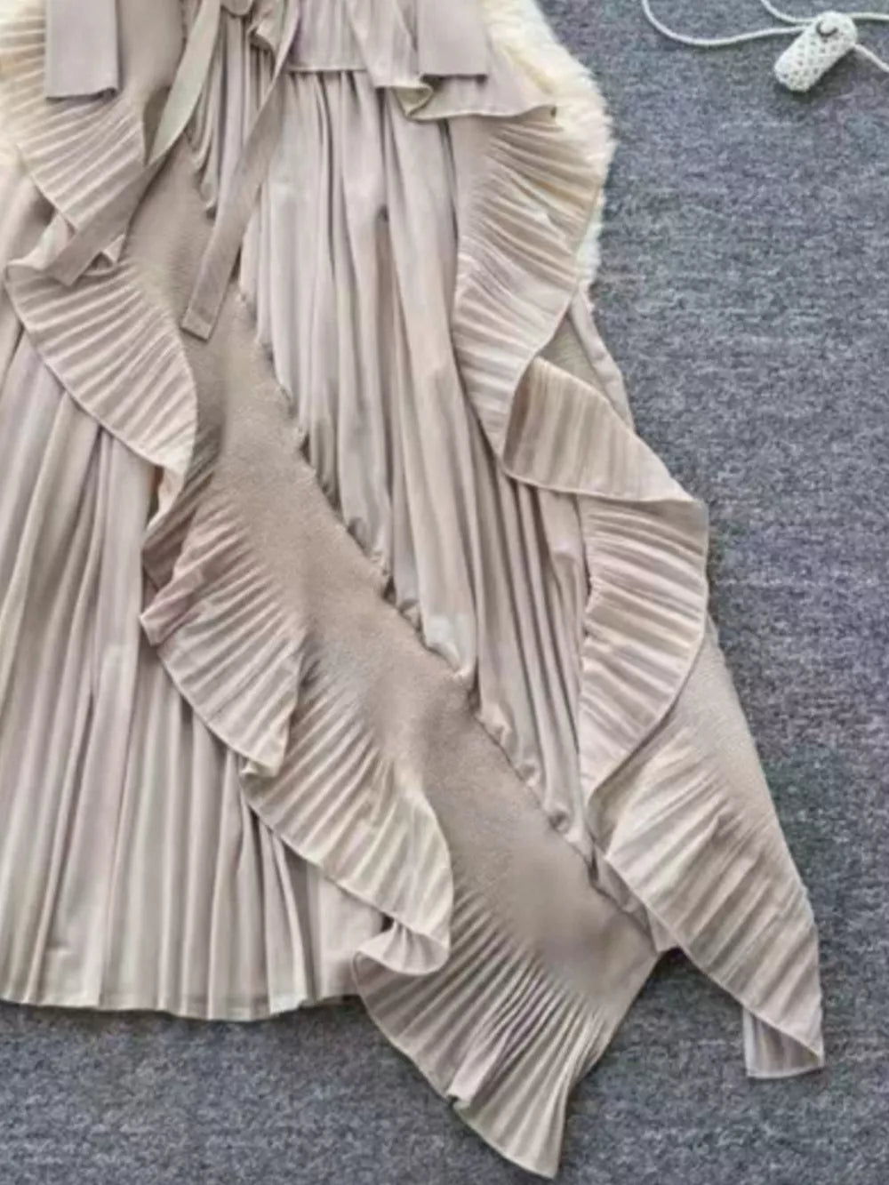 Elegant midi dress in apricot with ruffled pleats and asymmetrical hem.