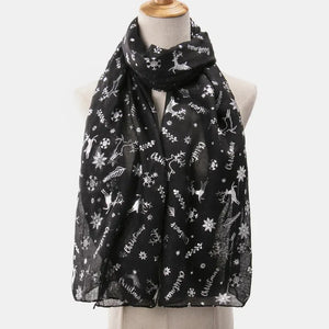 Black Christmas print metallic scarf with reindeer and snowflakes, on a mannequin.