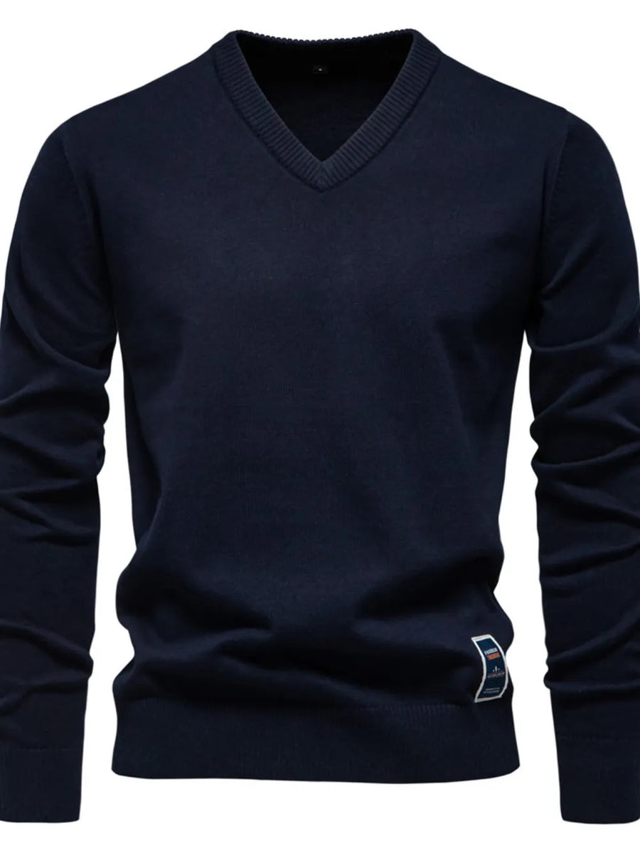 Navy ribbed knit V-neck sweater with a small logo tag on the hem.
