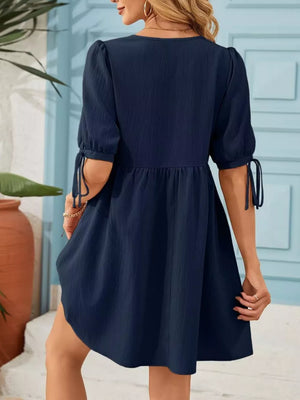 Navy puff sleeve mini dress with tie detail on sleeves and empire waist