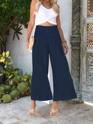 Navy smocked waist wide-leg pants with a textured fabric.