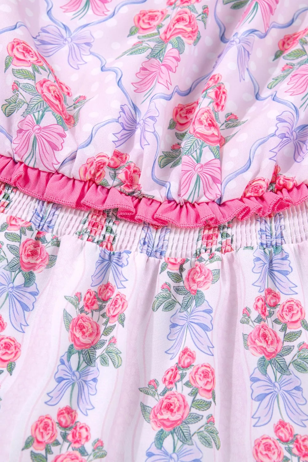 Floral tiered ruffle dress with pink roses and blue bows on a pink striped and polka dot background.