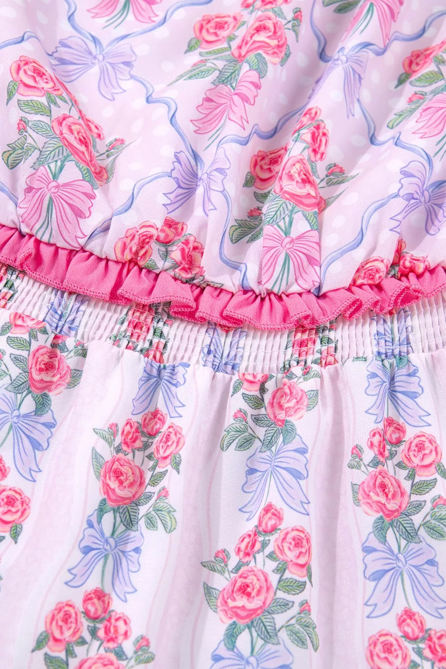 Floral tiered ruffle dress with pink roses and blue bows on a pink striped and polka dot background.