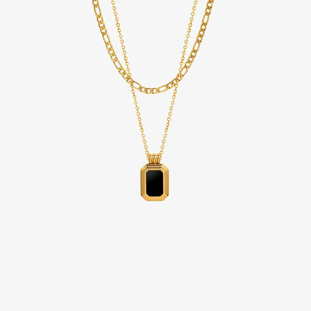 Gold double-layered necklace with figaro and curb chains, featuring an onyx inset rectangular pendant.