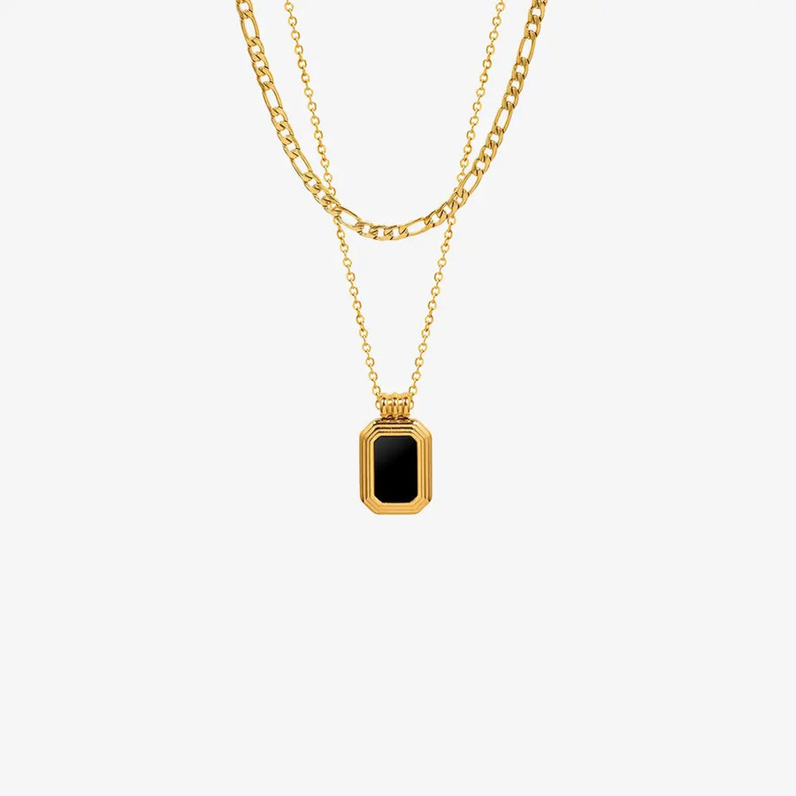 Gold double-layered necklace with figaro and curb chains, featuring an onyx inset rectangular pendant.