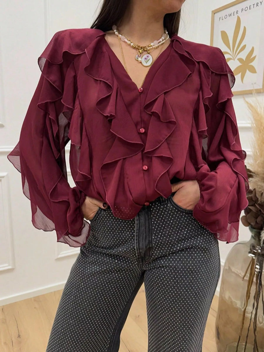 Burgundy sheer long-sleeve blouse with ruffled neckline and cuffs.