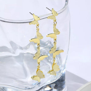 Gold earrings featuring dangling and butterfly