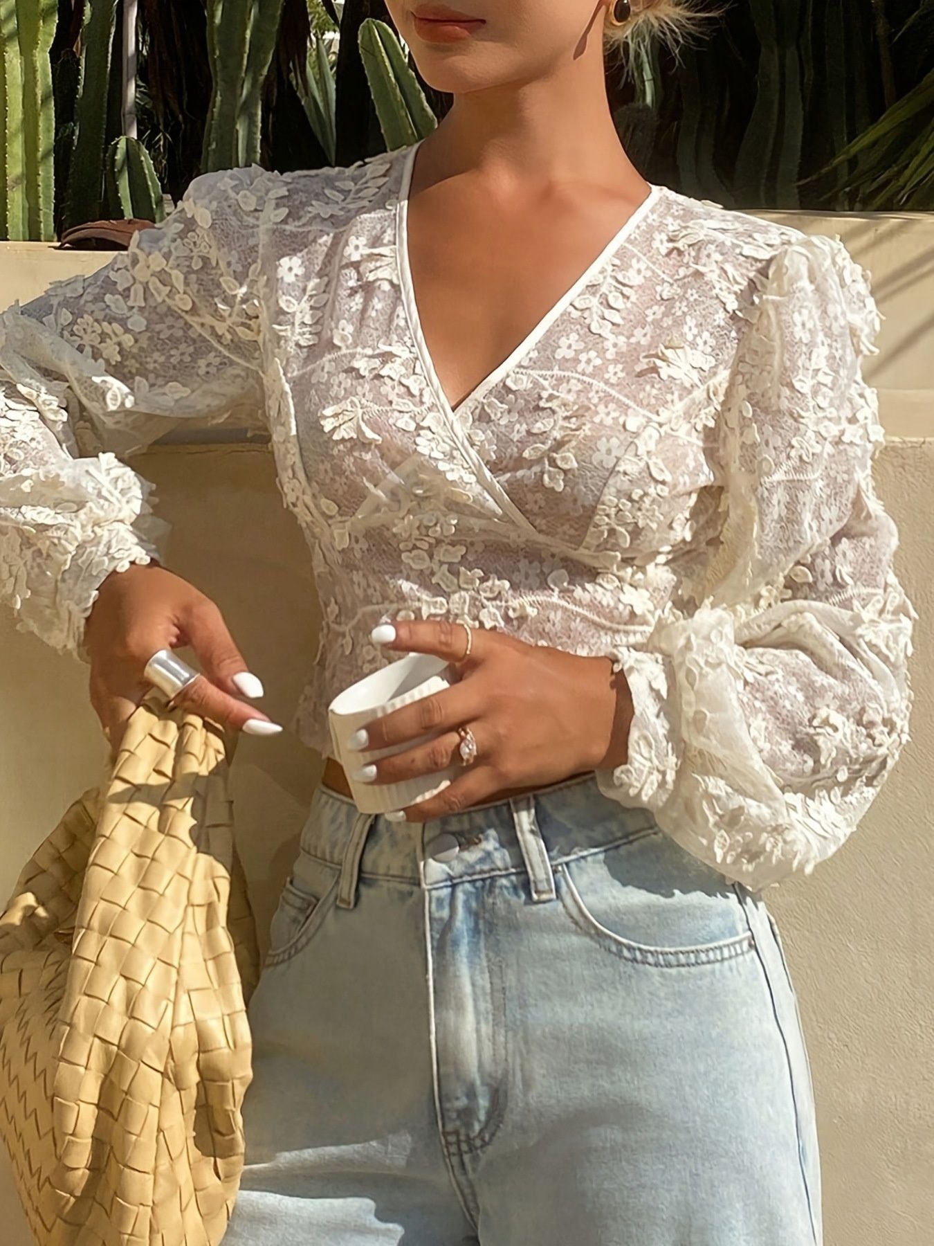 White lace sheer long sleeve blouse with floral applique and V-neckline.