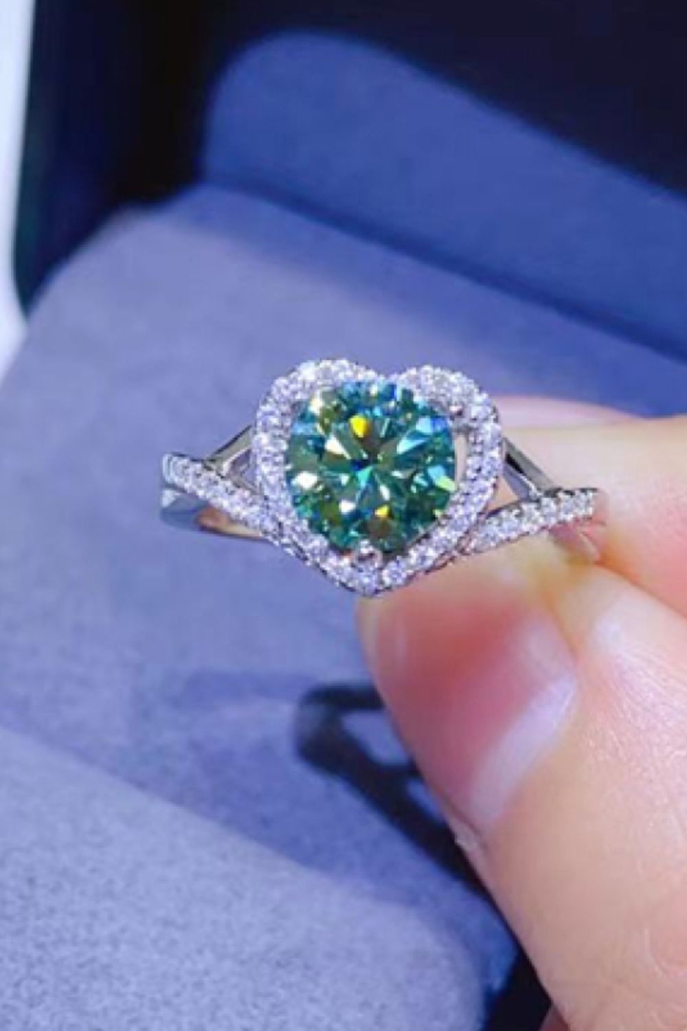 Green heart halo moissanite engagement ring in silver with diamond band.