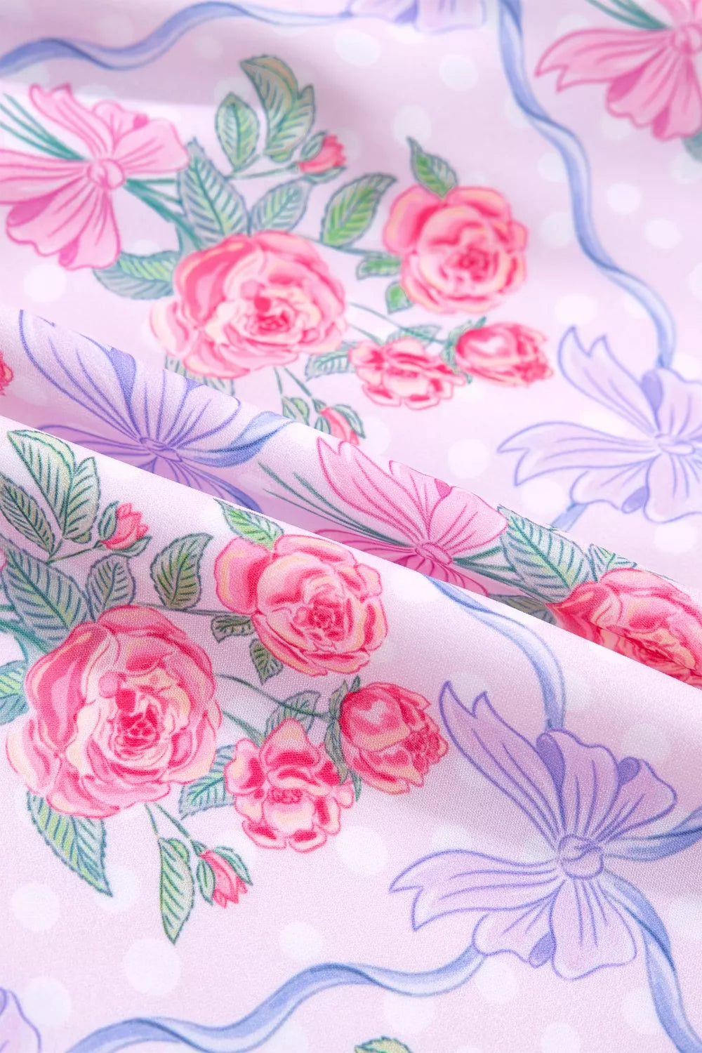 Floral tiered ruffle dress in pink with roses and bows print, featuring polka dots.