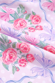 Floral tiered ruffle dress in pink with roses and bows print, featuring polka dots.