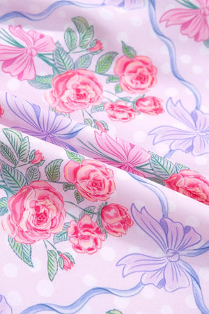 Floral tiered ruffle dress in pink with roses and bows print, featuring polka dots.