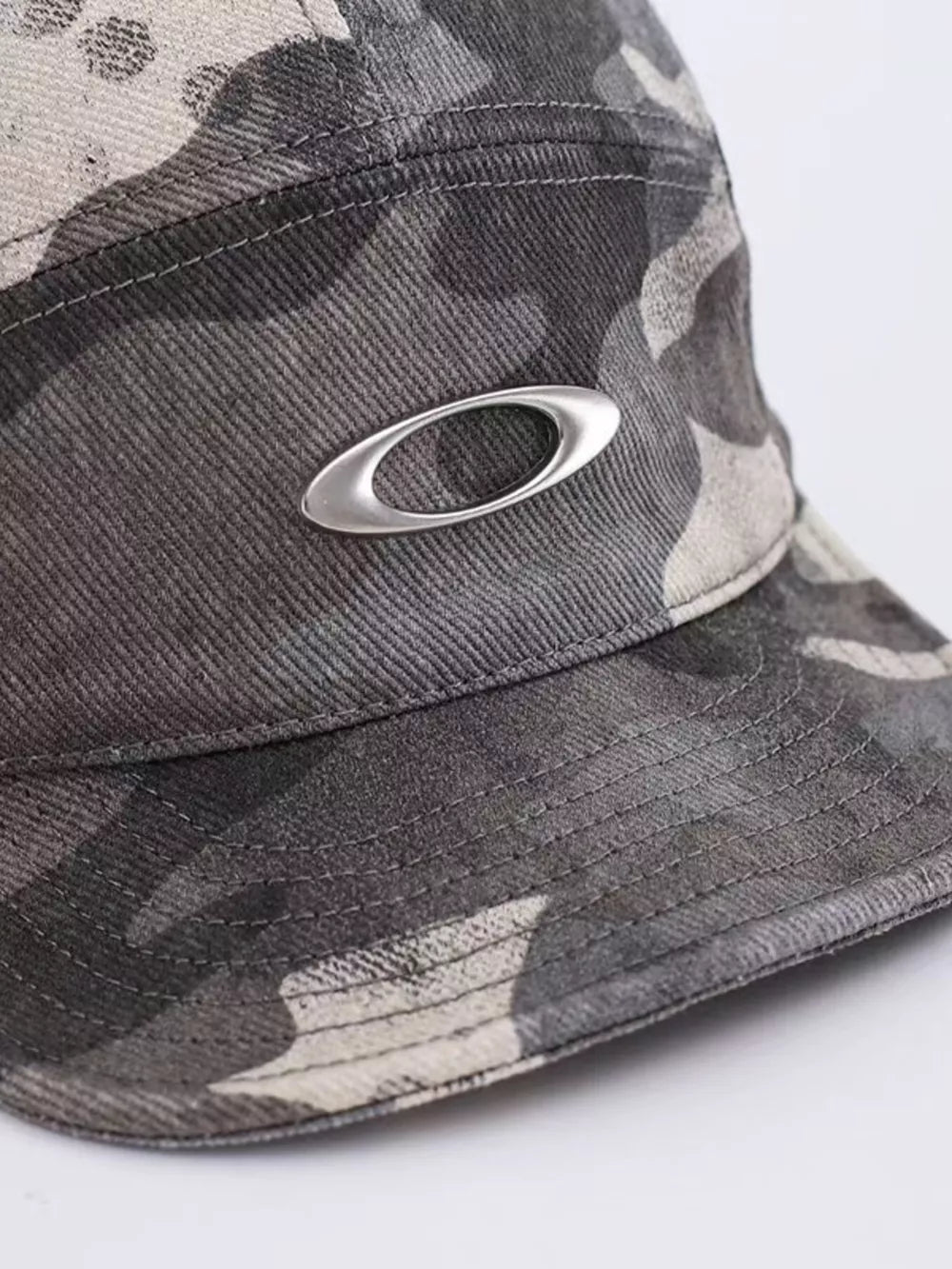 Oakley camouflage baseball cap with silver logo detail.