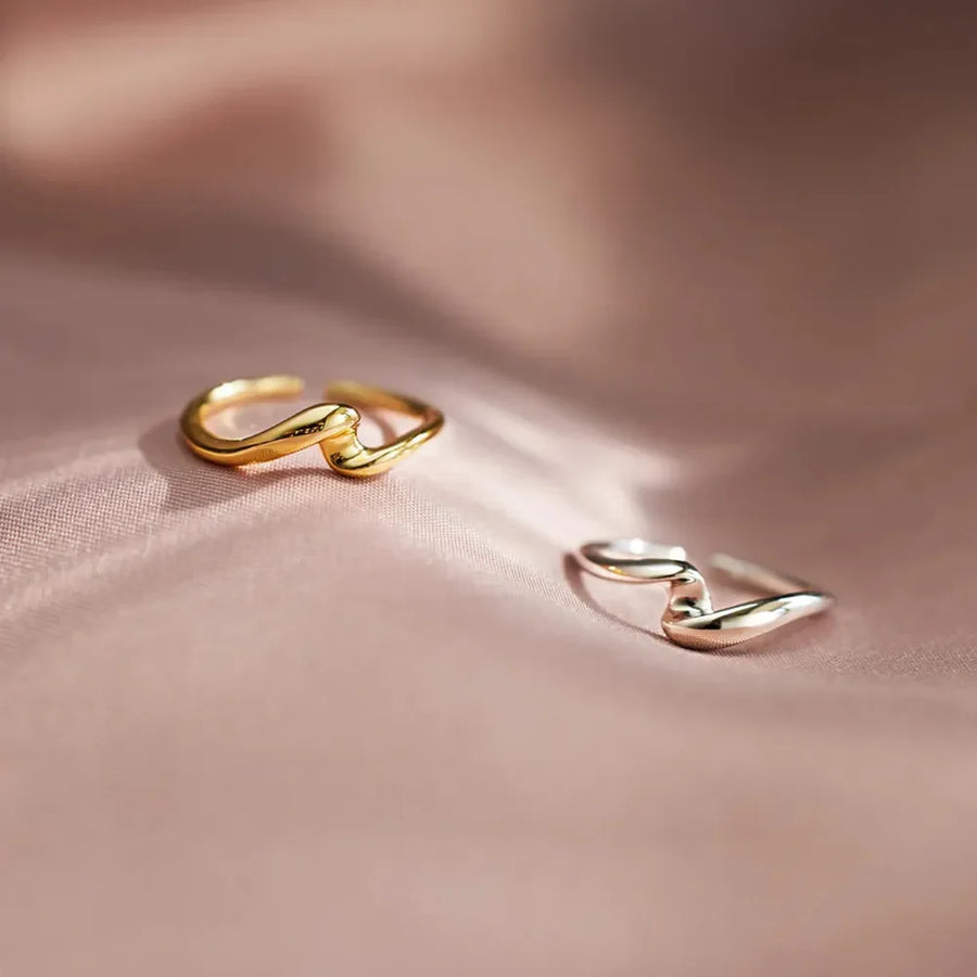 Gold two-tone intertwined open ring with a wavy design.
