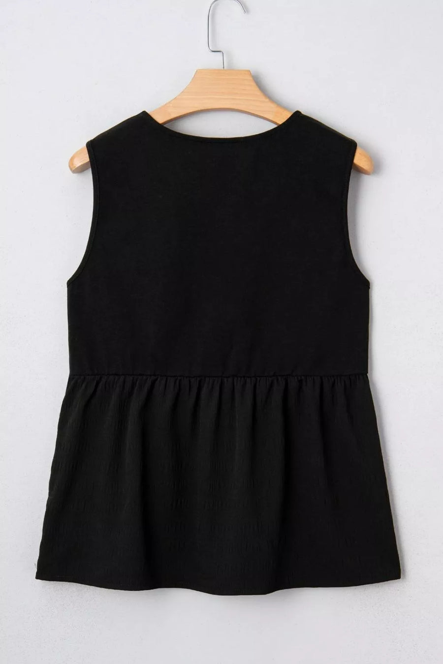 Black sleeveless peplum top with textured fabric and round neckline