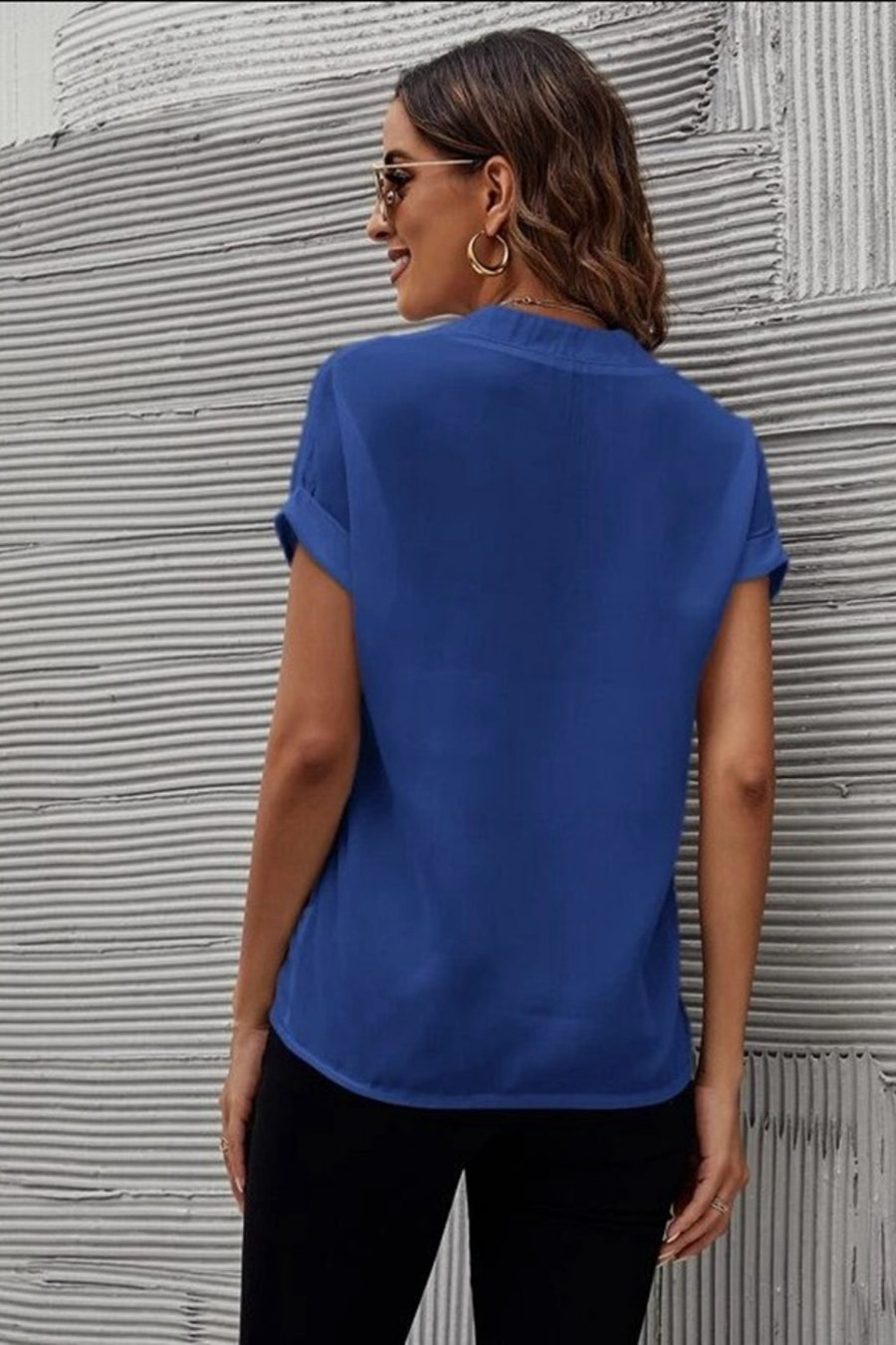Royal blue blouse with cuffed short sleeves and a V-neckline, shown from the back.