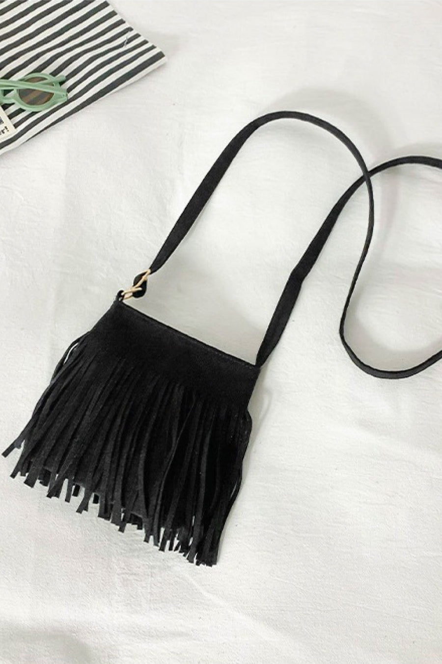 Black suede crossbody bag with fringe detail and adjustable strap