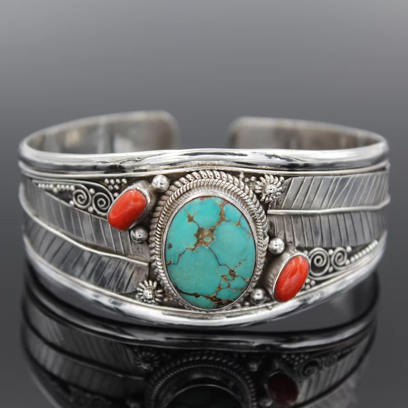 Turquoise and coral feather cuff bracelet in silver with intricate detailing.