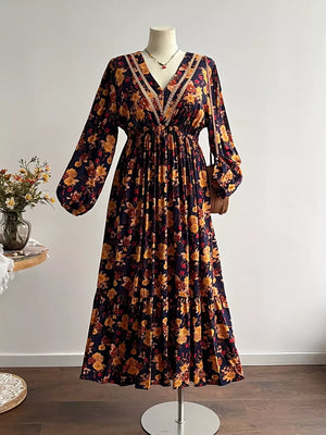 Maxi dress with V-neck, long sleeves, and floral print in navy with yellow and red flowers.