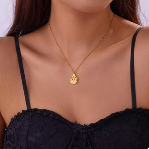 Gold necklace featuring pendant and figural