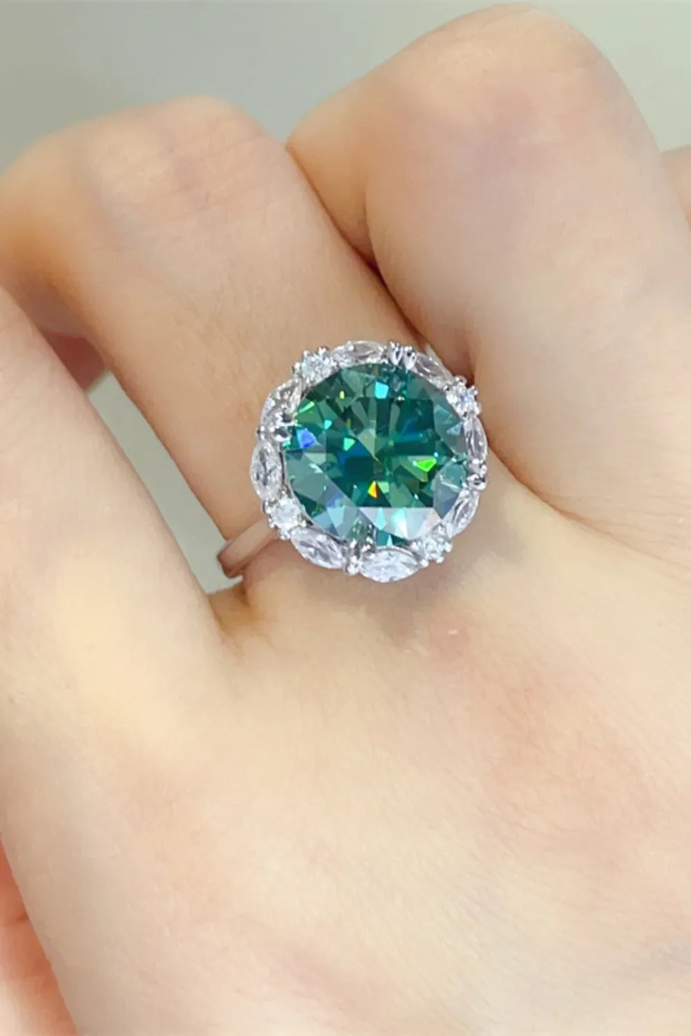 Emerald halo sterling silver cocktail ring with a large dark green center stone.