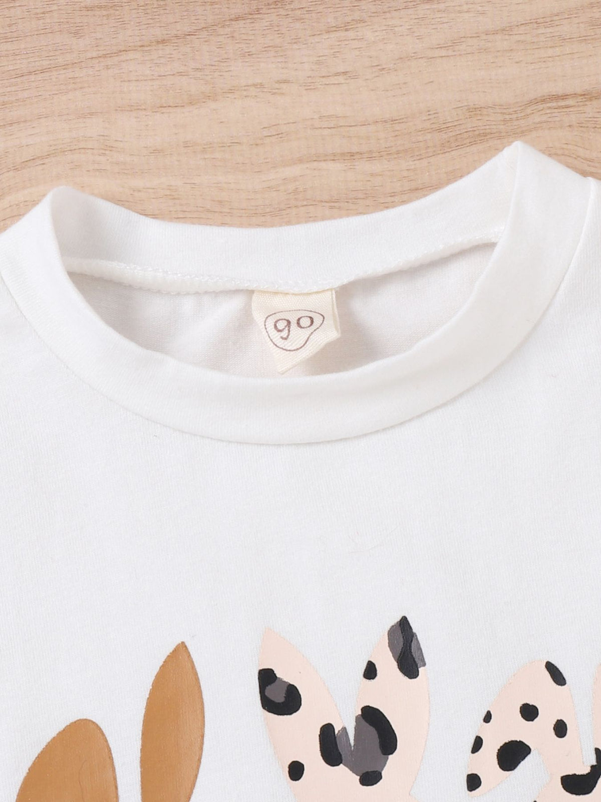 White toddler t-shirt with Easter bunny graphic and leopard print ears.