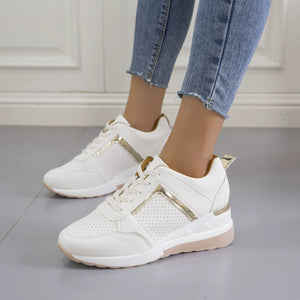 White lace-up wedge sneakers with metallic gold accents and perforated details.