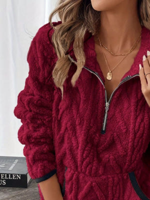 Burgundy sherpa half zip sweatshirt with textured pattern and zipper detail.