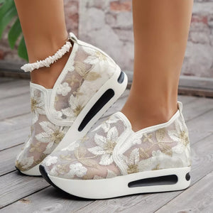 White floral embroidered mesh slip-on sneakers with a chunky platform sole.