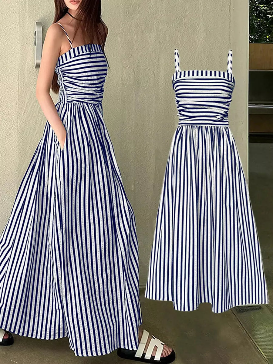 Navy blue and white striped maxi dress with spaghetti straps, cinched waist, and pockets.