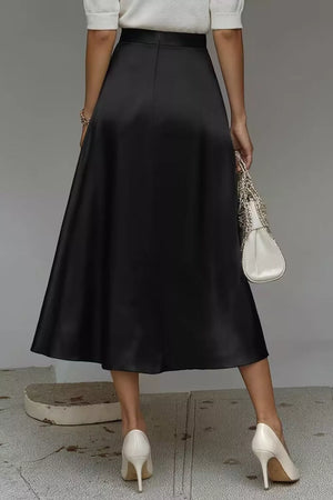 Black a-line midi skirt with a lustrous finish and hidden pockets.