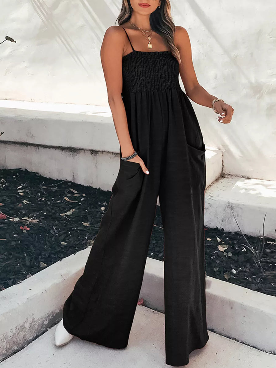 Black smocked wide leg romper with spaghetti straps and side pockets
