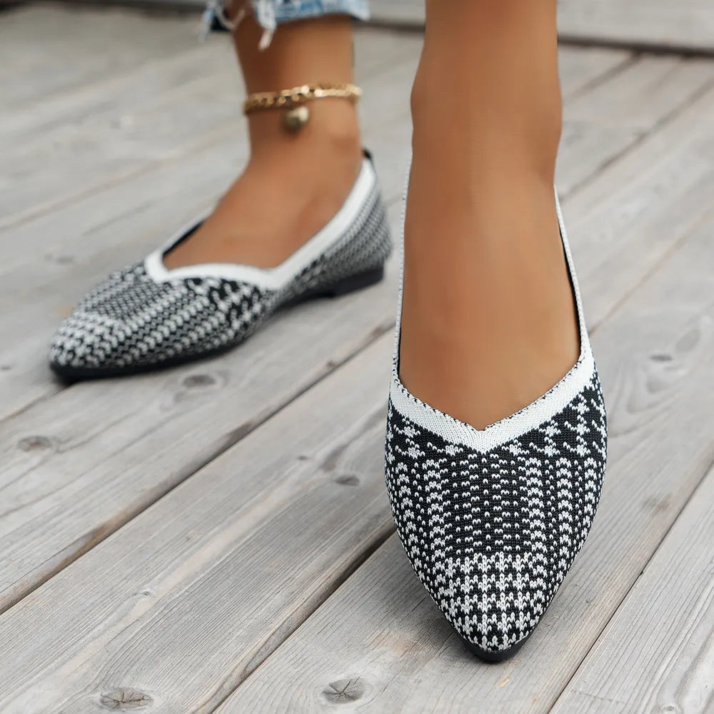 Geometric knit pointed ballet flats in black and white houndstooth pattern with white trim.