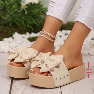 Ribbed bow accent platform sandals in white with beige platform and stud detail.