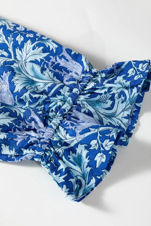 Blue floral cotton midi dress with cinched waist and frilled cuffs.