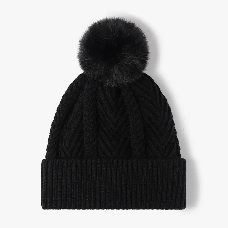 Black chevron knit beanie with a fluffy pom and ribbed cuff.